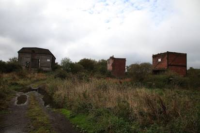 A dirt path leading to a ruined building
Description automatically generated with medium confidence